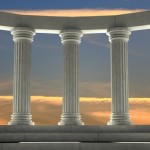 Ancient marble pillars in elliptical arrangement with orange sky