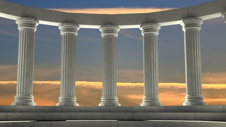 Ancient marble pillars in elliptical arrangement with orange sky